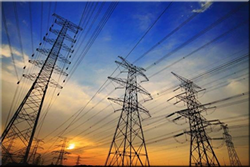 Tall power lines in front of a sunset